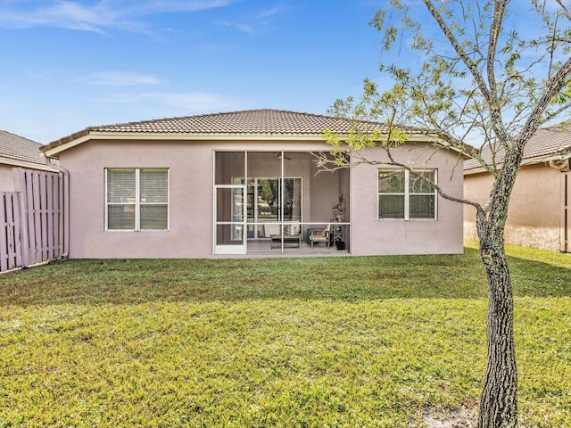 back of property featuring a sunroom, a patio area, and a yard