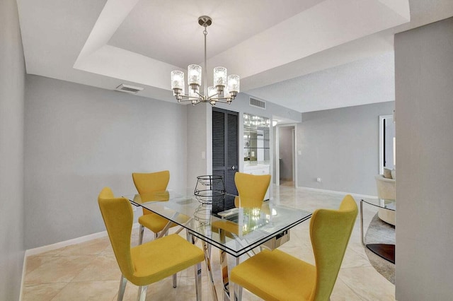 dining room featuring a raised ceiling and an inviting chandelier