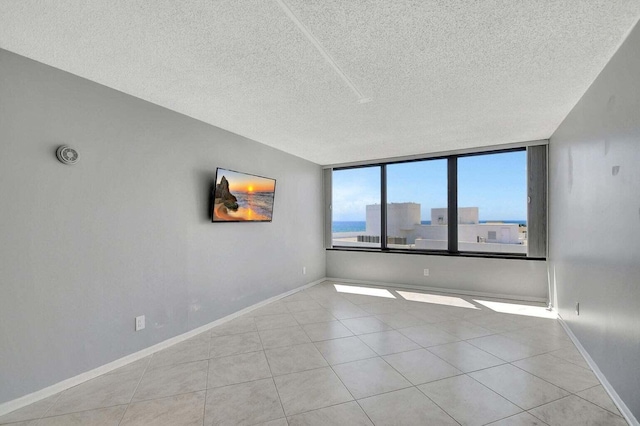 tiled empty room with a textured ceiling