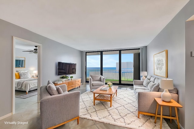 tiled living room with ceiling fan and expansive windows