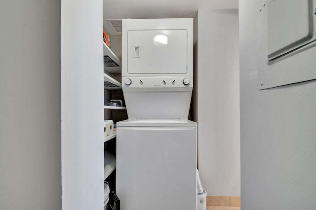 laundry area featuring stacked washer / drying machine