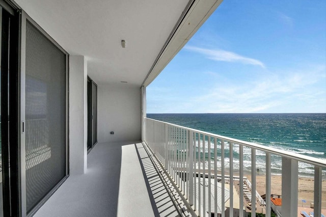 balcony featuring a water view and a view of the beach