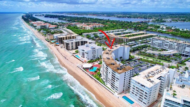 birds eye view of property with a water view and a beach view