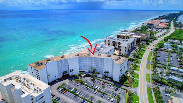 birds eye view of property with a water view and a beach view