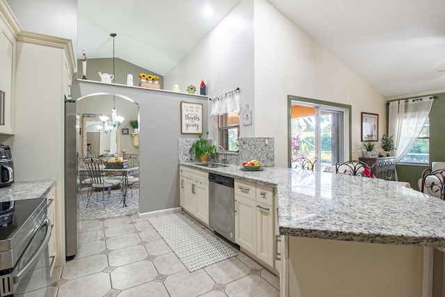 kitchen with sink, stainless steel appliances, tasteful backsplash, light stone counters, and kitchen peninsula