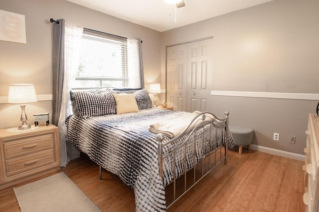 bedroom with a closet, light hardwood / wood-style flooring, and ceiling fan