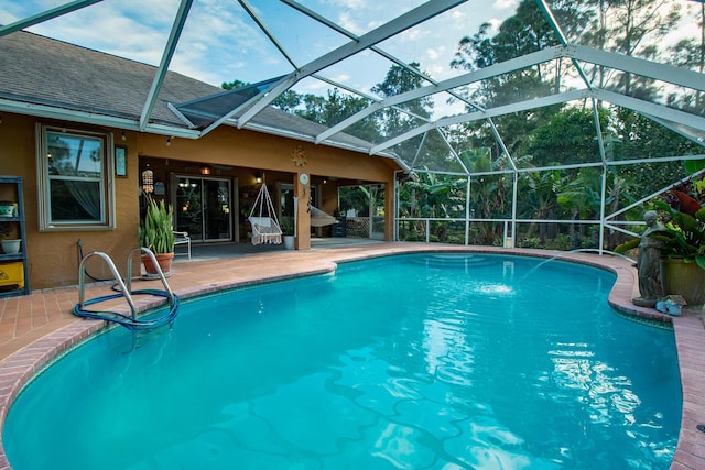 view of pool with a patio and glass enclosure