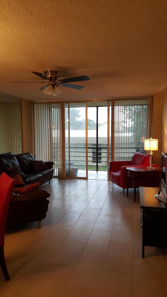 tiled living room featuring ceiling fan and a textured ceiling