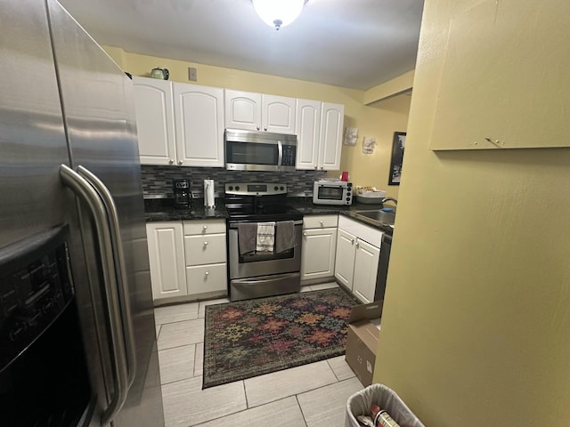 kitchen with white cabinets, appliances with stainless steel finishes, decorative backsplash, and sink