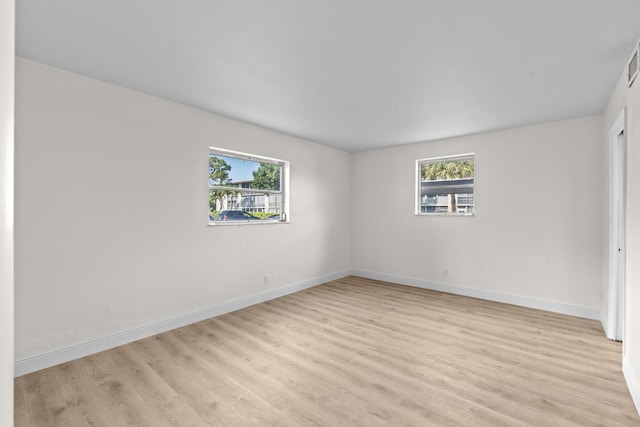 unfurnished room with plenty of natural light and light hardwood / wood-style flooring