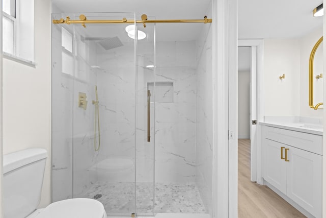 bathroom with hardwood / wood-style flooring, vanity, toilet, and an enclosed shower