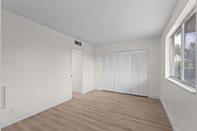 unfurnished bedroom featuring a closet and light hardwood / wood-style floors