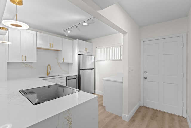 kitchen featuring white cabinets, light wood-type flooring, stainless steel appliances, and sink