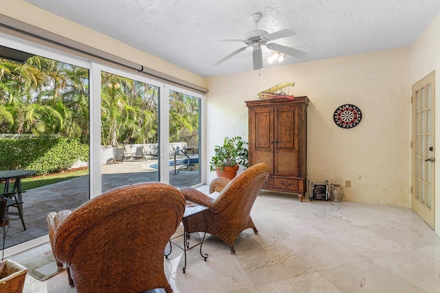 sunroom / solarium featuring ceiling fan