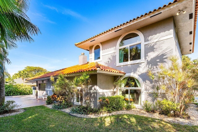 view of front of house featuring a patio area and a front lawn