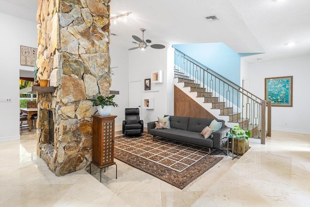 living room with ceiling fan and a textured ceiling