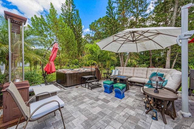 view of patio / terrace with a hot tub and an outdoor living space with a fire pit