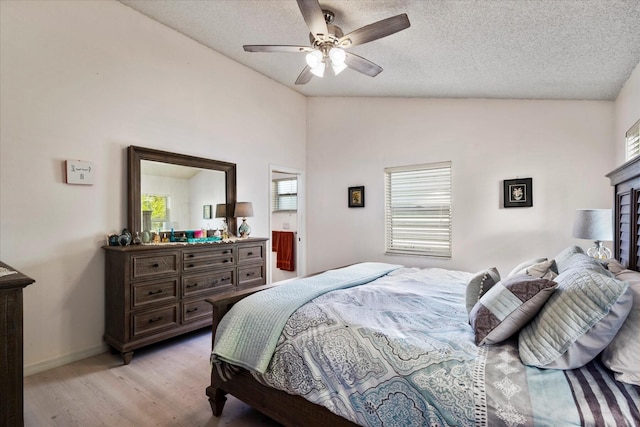 bedroom featuring light hardwood / wood-style floors, multiple windows, lofted ceiling, and ceiling fan