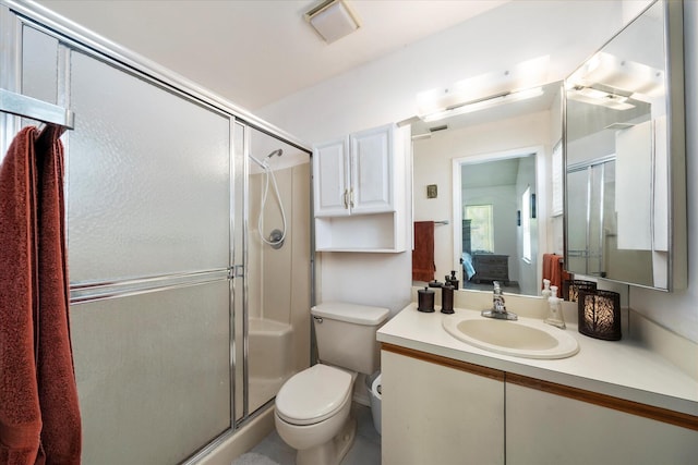 bathroom featuring a shower with door, vanity, and toilet