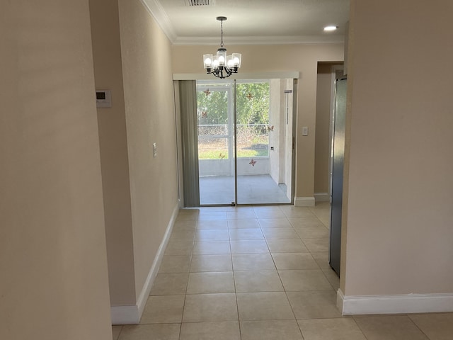 entryway with a notable chandelier, light tile patterned flooring, and ornamental molding