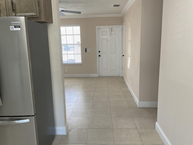 entryway with light tile patterned floors, ceiling fan, and crown molding