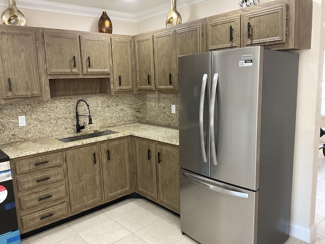 kitchen featuring sink, stainless steel fridge, crown molding, decorative backsplash, and light tile patterned flooring