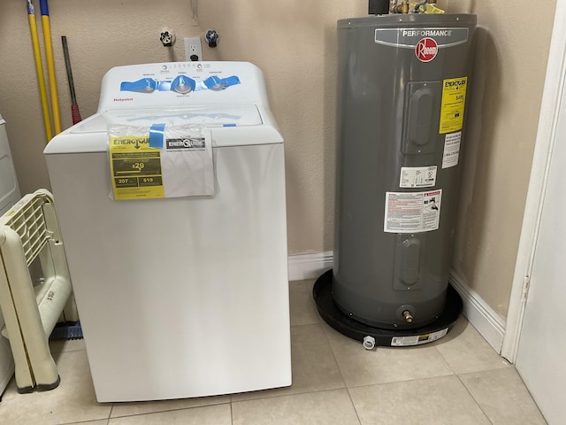 utility room with electric water heater and washer / dryer