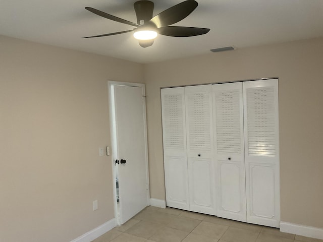 unfurnished bedroom featuring ceiling fan, a closet, and light tile patterned floors