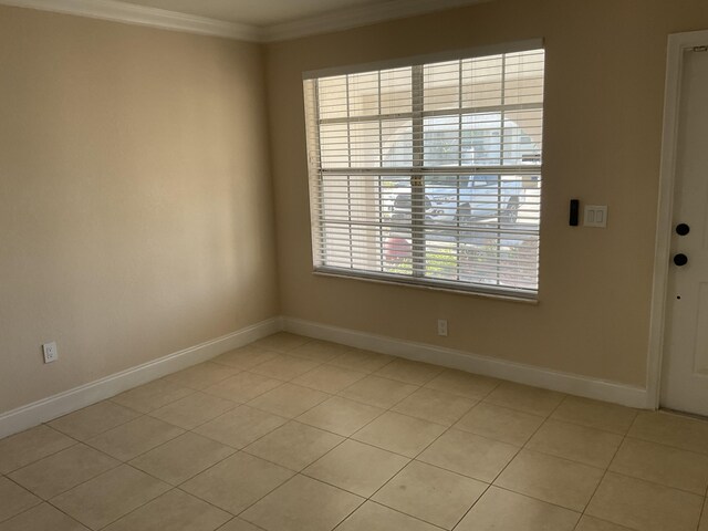 spare room featuring crown molding and light tile patterned flooring