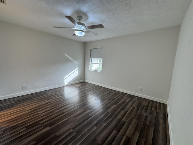 empty room with ceiling fan, dark hardwood / wood-style flooring, and a textured ceiling