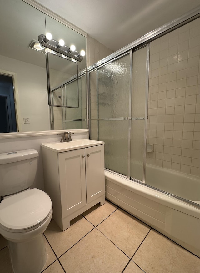 full bathroom with toilet, vanity, tile patterned floors, and bath / shower combo with glass door