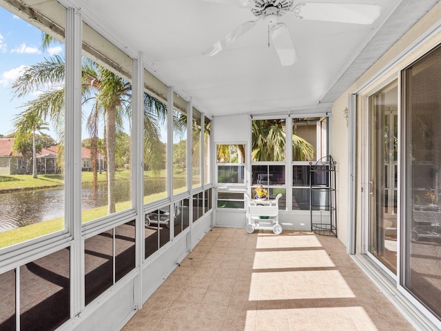 unfurnished sunroom featuring ceiling fan, plenty of natural light, and a water view