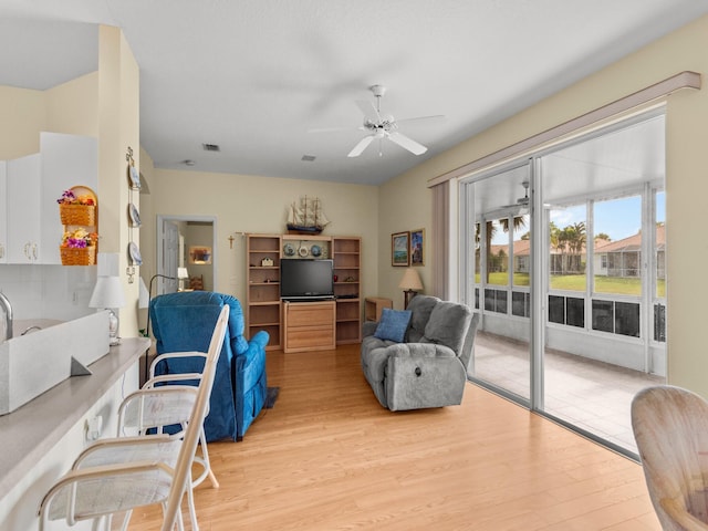 living room featuring light wood-type flooring and ceiling fan