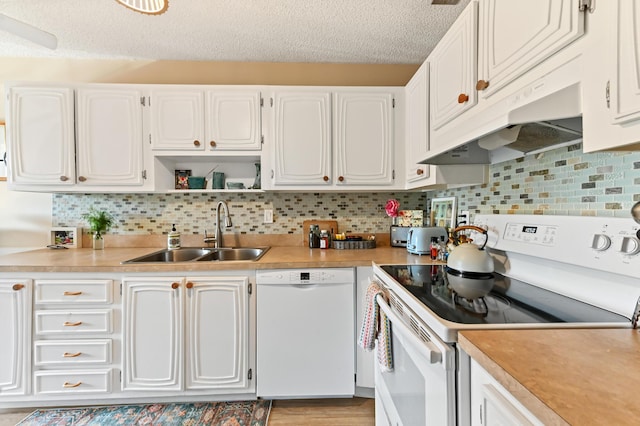 kitchen with white cabinetry, sink, a textured ceiling, white appliances, and decorative backsplash