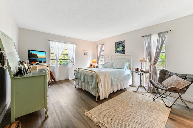 bedroom featuring a textured ceiling and dark wood-type flooring