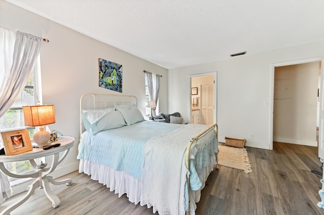 bedroom featuring hardwood / wood-style floors and a textured ceiling