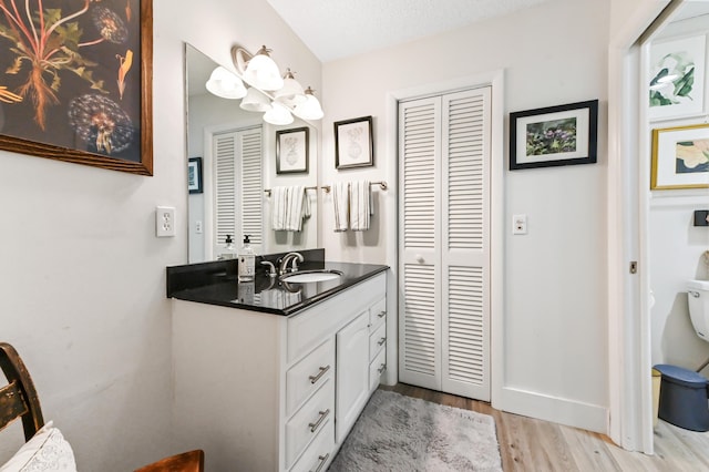 bathroom with hardwood / wood-style floors, vanity, and a textured ceiling