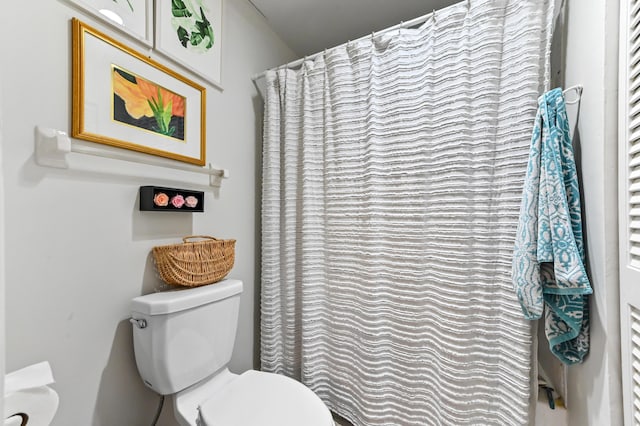 bathroom featuring a shower with curtain and toilet