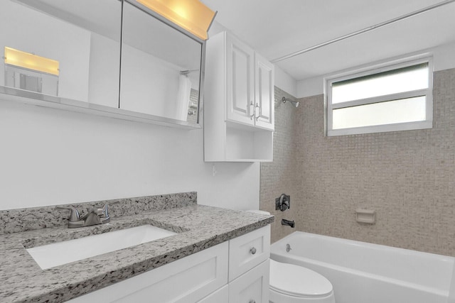 full bathroom with vanity, tiled shower / bath combo, and toilet