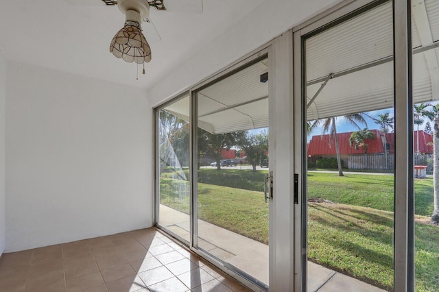 doorway featuring ceiling fan and light tile patterned floors