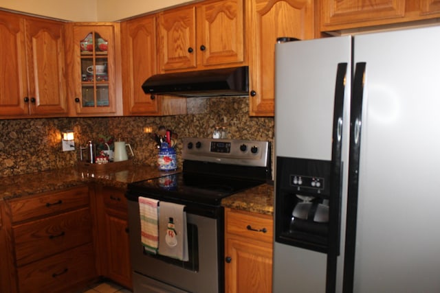 kitchen featuring stainless steel appliances, tasteful backsplash, and dark stone counters