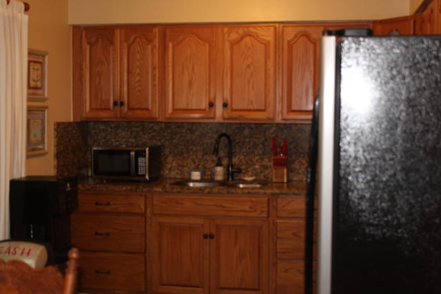 kitchen featuring tasteful backsplash, sink, and stainless steel fridge