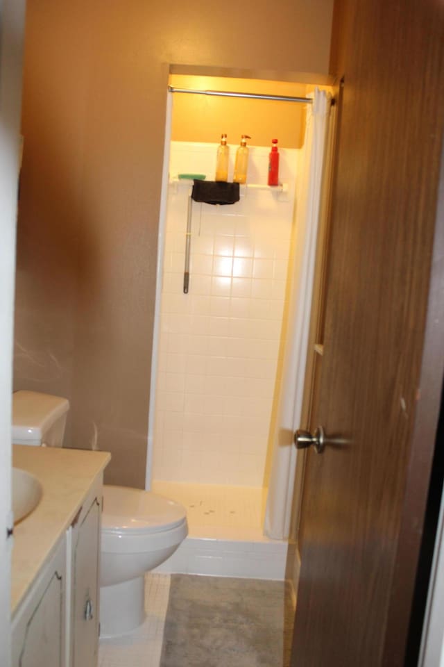 bathroom featuring vanity, curtained shower, tile patterned floors, and toilet