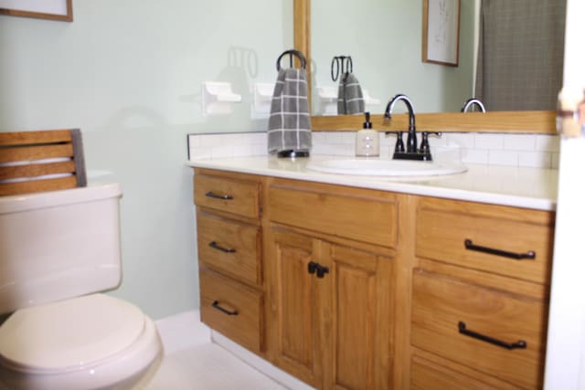 bathroom featuring vanity, tile patterned floors, and toilet