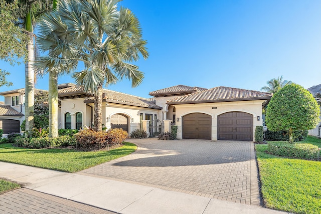 mediterranean / spanish home featuring a front yard and a garage