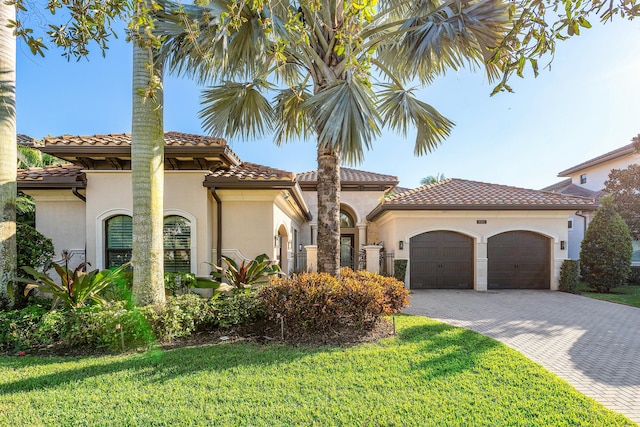 mediterranean / spanish-style house featuring a front yard and a garage