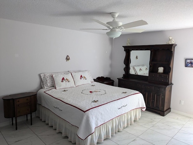 bedroom with ceiling fan and a textured ceiling