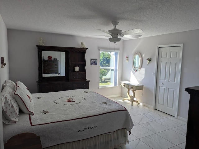 bedroom with ceiling fan and a textured ceiling