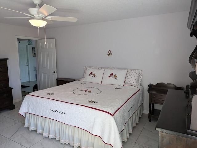 bedroom with ceiling fan and a textured ceiling