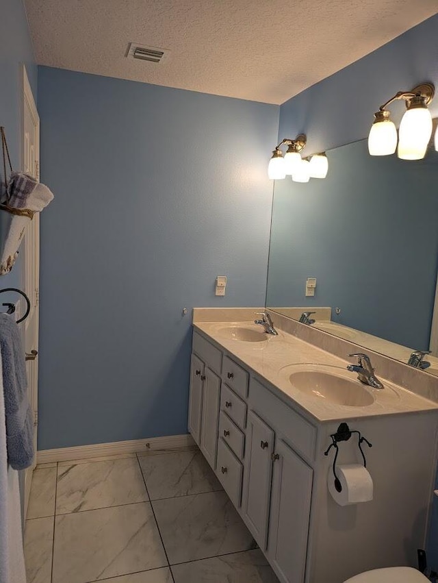 bathroom with vanity and a textured ceiling